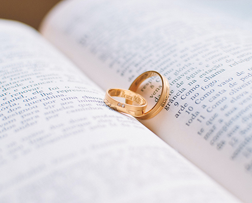 Two wedding rings sitting in the middle of a bible