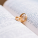 Two wedding rings sitting in the middle of a bible