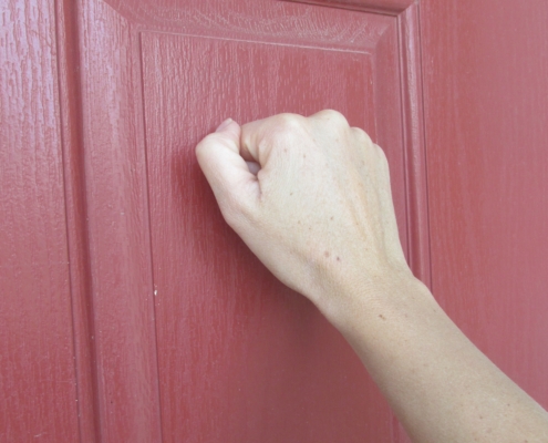 Someone knocking on a red coloured door