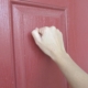 Someone knocking on a red coloured door