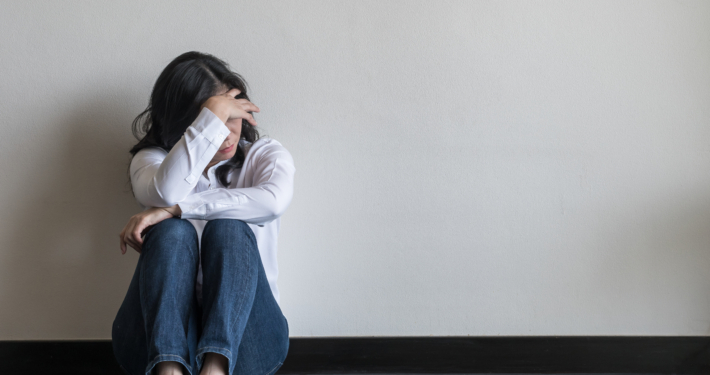 A woman sat on the floor in distress
