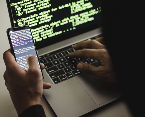 Someone looking at their phone and their laptop