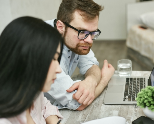 A man and a woman looking at a laptop