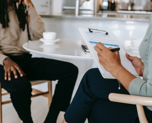 Two people sitting at a desk talking