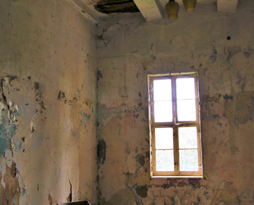 An abandoned house with a chair inside