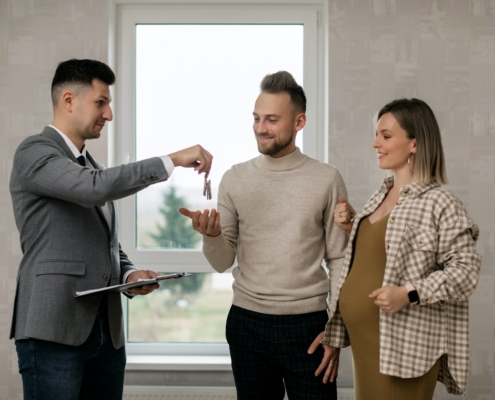 A property landlord giving keys to a man and a woman