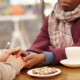 Two people sitting down at a table with tea/coffee