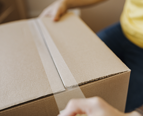 Someone Sellotaping a cardboard box