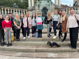 A group of people standing around a monument