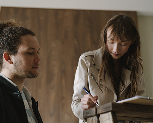 A woman looking at her notes with another man