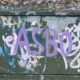 A telephone junction box daubed with graffiti. The box is situated outside the Brighton & Hove School in Hove, Sussex, England. The most prominent tag is "ASBO", short for Anti-Social Behaviour order