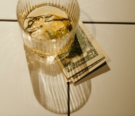 A spirit glass with cash under it