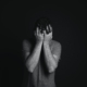 A man with covering his face with his hands