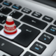 Miniature traffic cone with caution written on it, resting on a laptop keyboard - Data protection claims are on the rise.