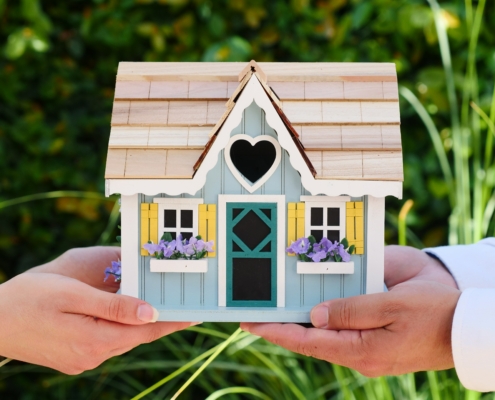 A woman and a man holding a house model