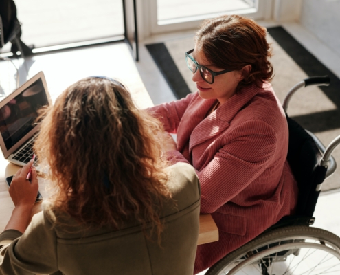 Two people talking at a desk