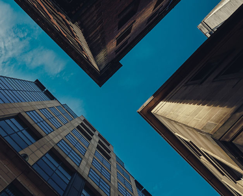 View of the sky looking upwards between three tall buildings