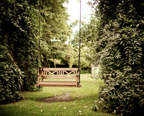 An empty swinging bench in a forest
