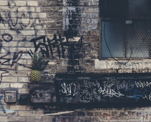 A brick wall with grafiti covered on it