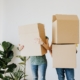 Two people holding cardboard boxes