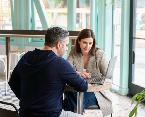 A man and a woman looking at a laptop