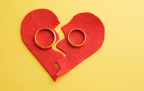 A love heart split in two with rings either side